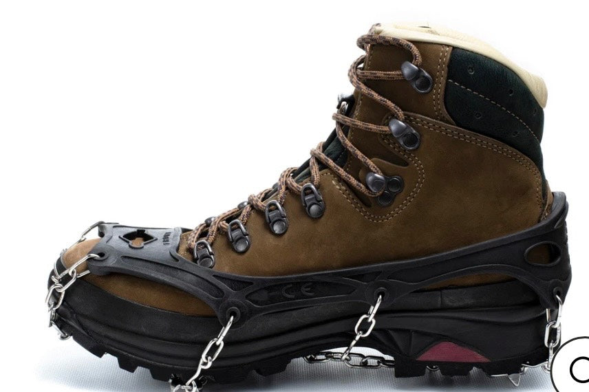 Brown hiking boot with cleats on a white background