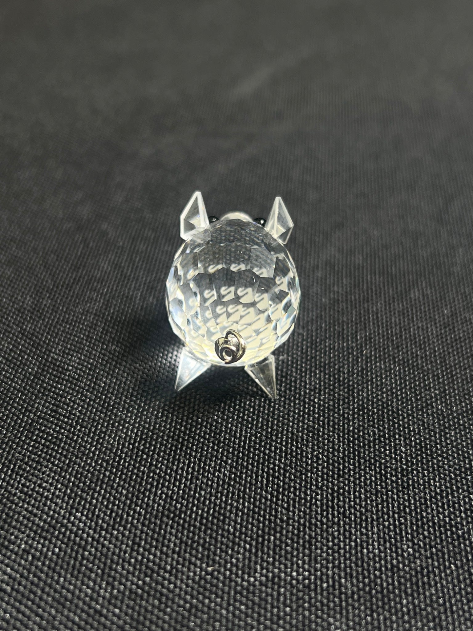 Clear crystal object shaped like a cat on a black background