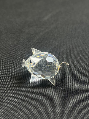 Clear crystal fish-shaped object on a black textured background