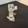 Clear plastic robot figure on a black surface