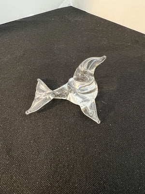 Clear glass dolphin figurine on a dark surface