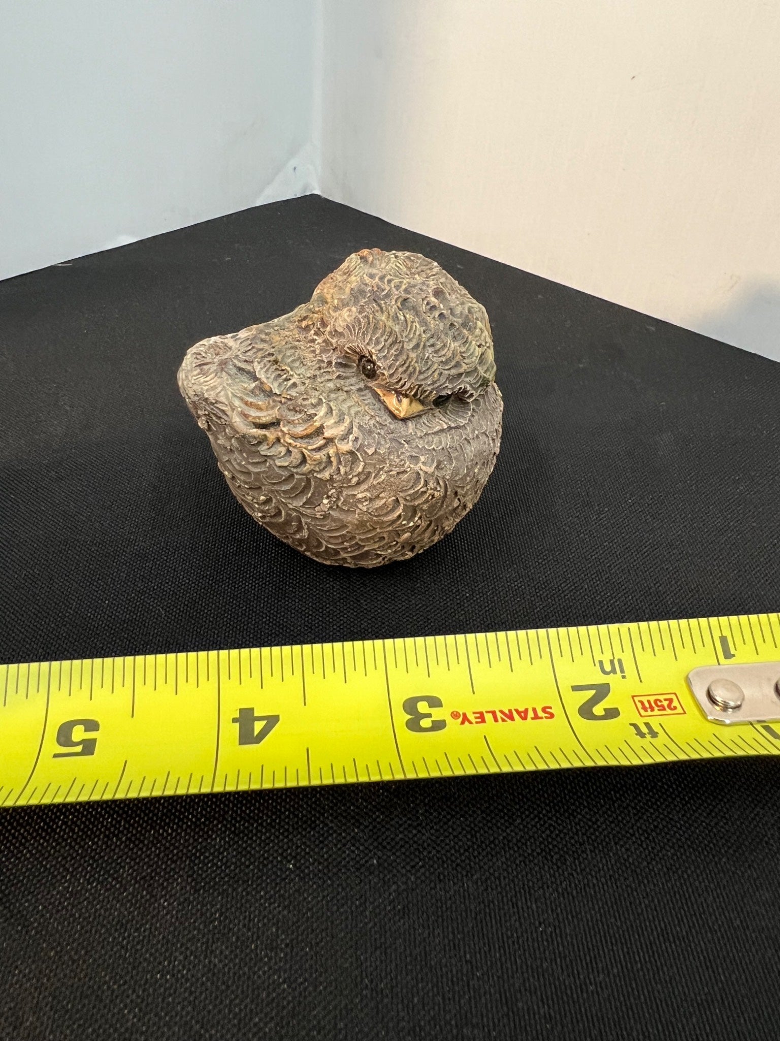 Rock on a black surface with a yellow measuring tape