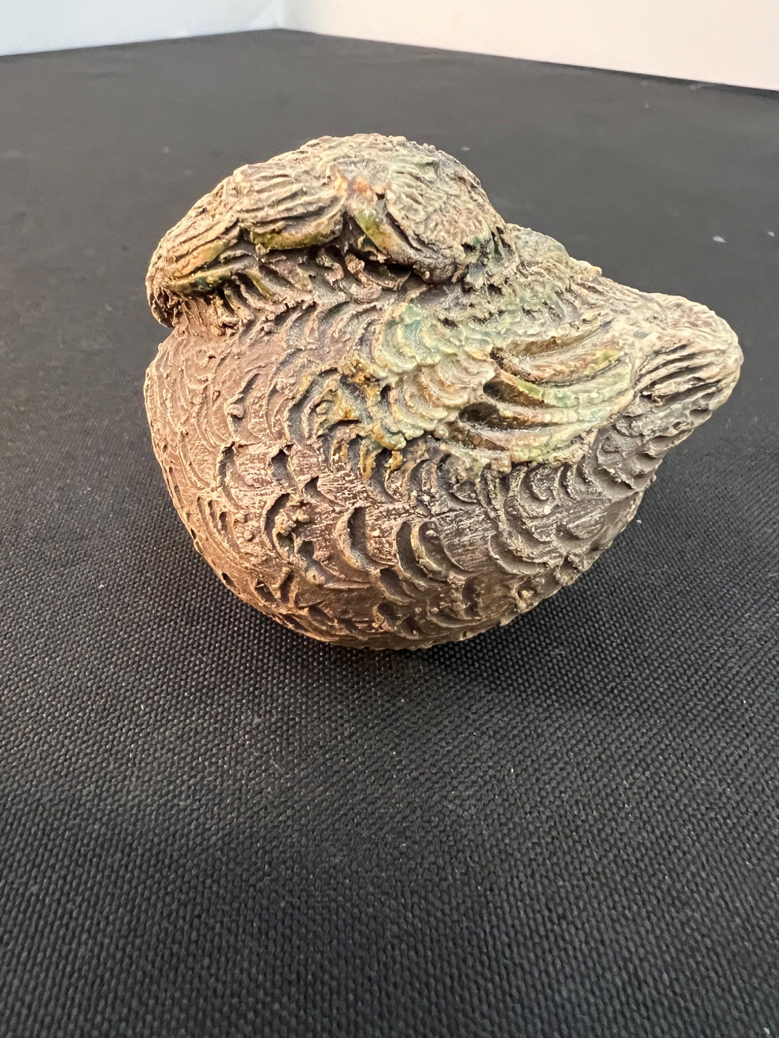 Decorative ceramic bird on a black surface