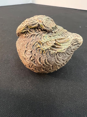 Decorative ceramic bird on a black surface