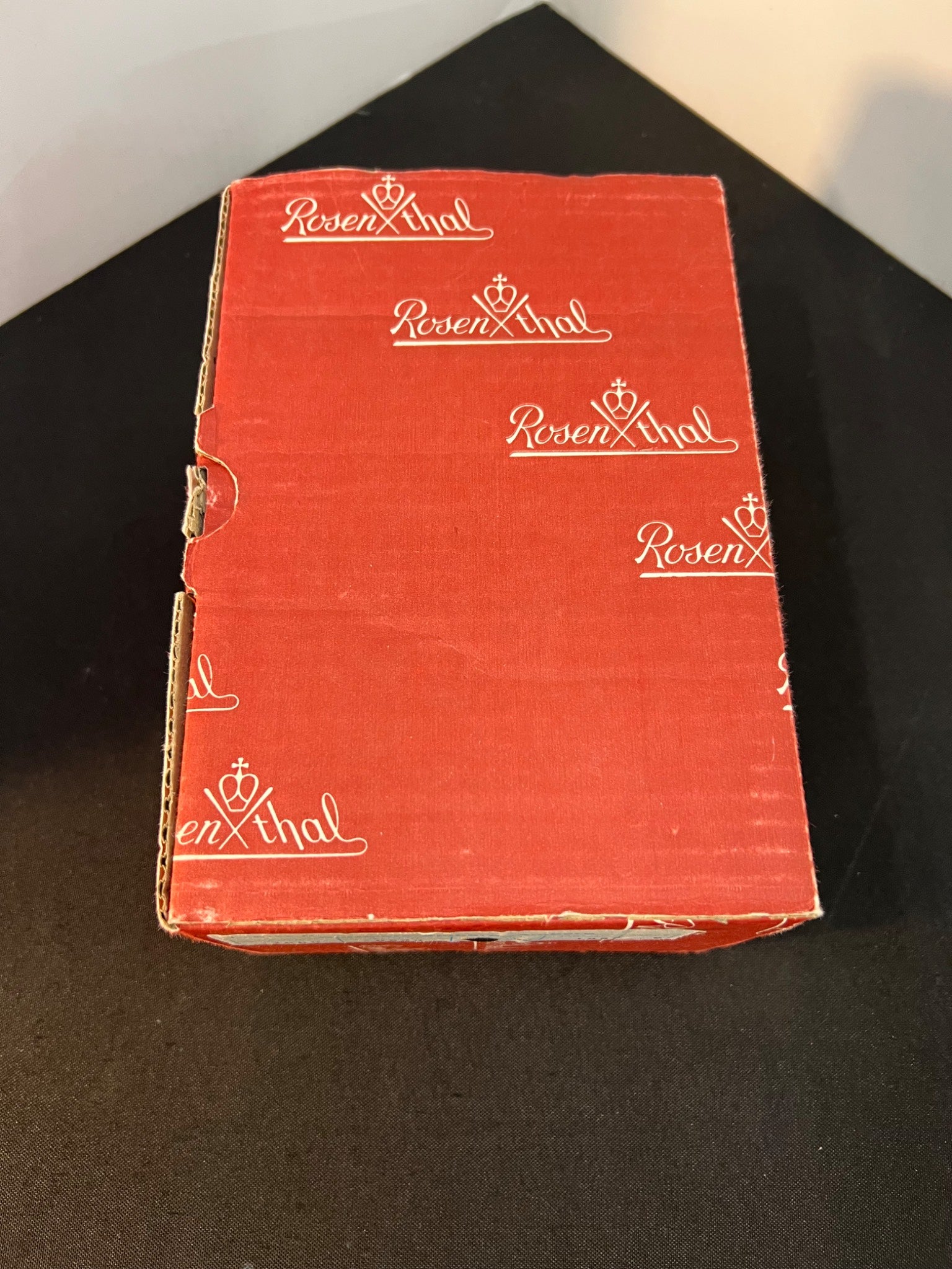Red box with 'Rosen & Hal' branding on a black surface