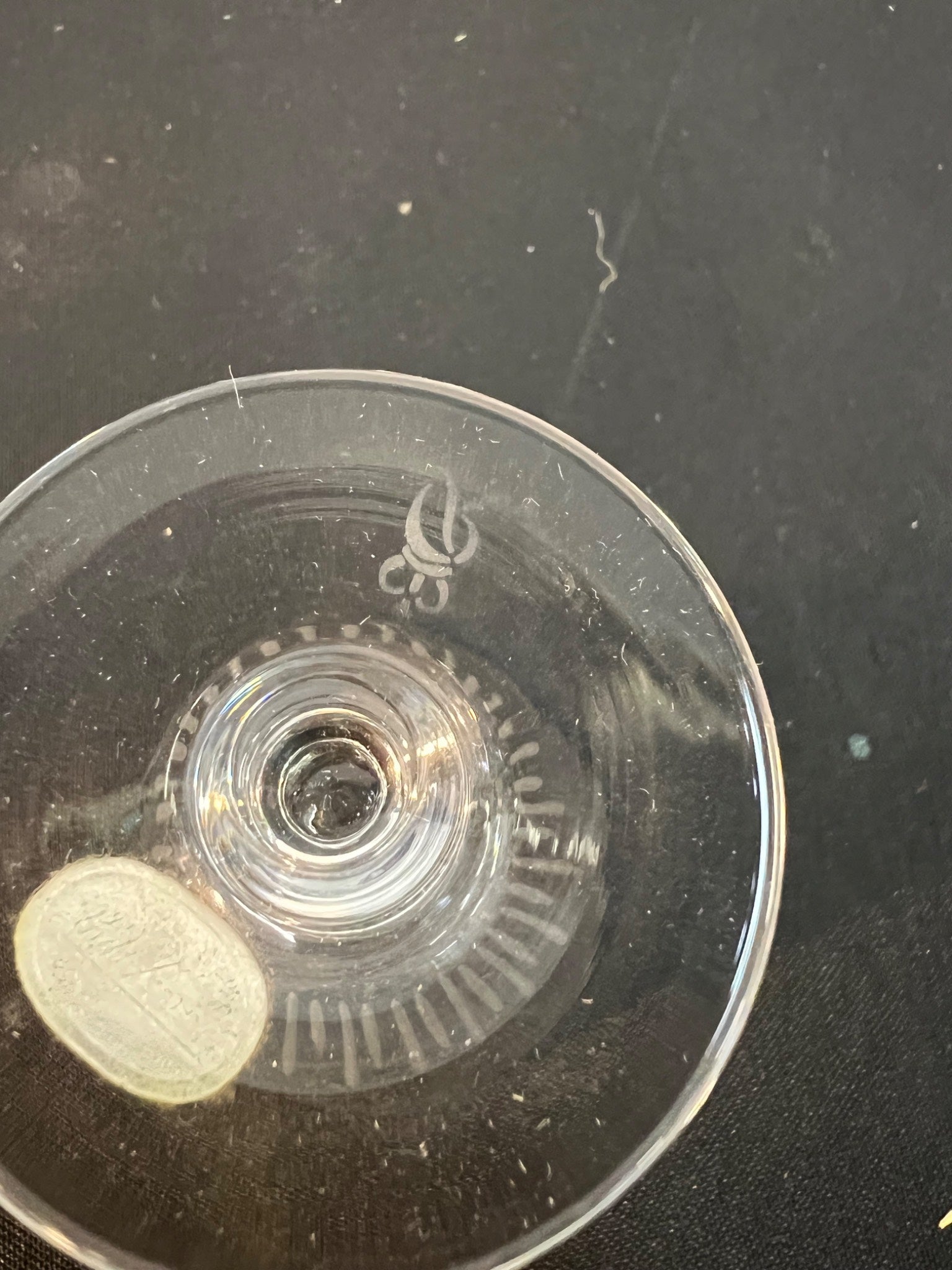 Clear plastic component with gear-like design on a dark background