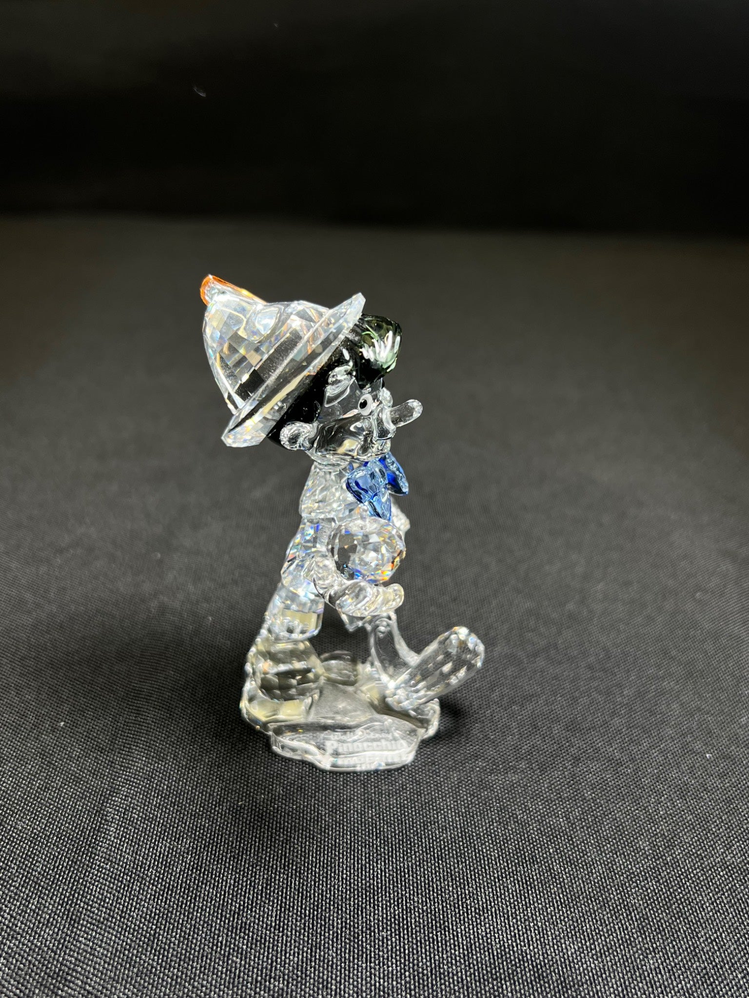 Crystal figurine of a dog with a hat on a dark background