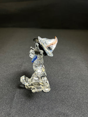 Crystal dog figurine with a black hat on a gray background