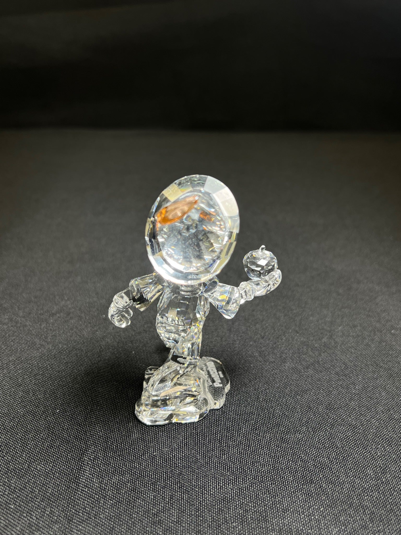 Clear glass figurine on a dark gray background