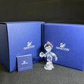 Swarovski crystal figurine with blue packaging and certificate on a dark background