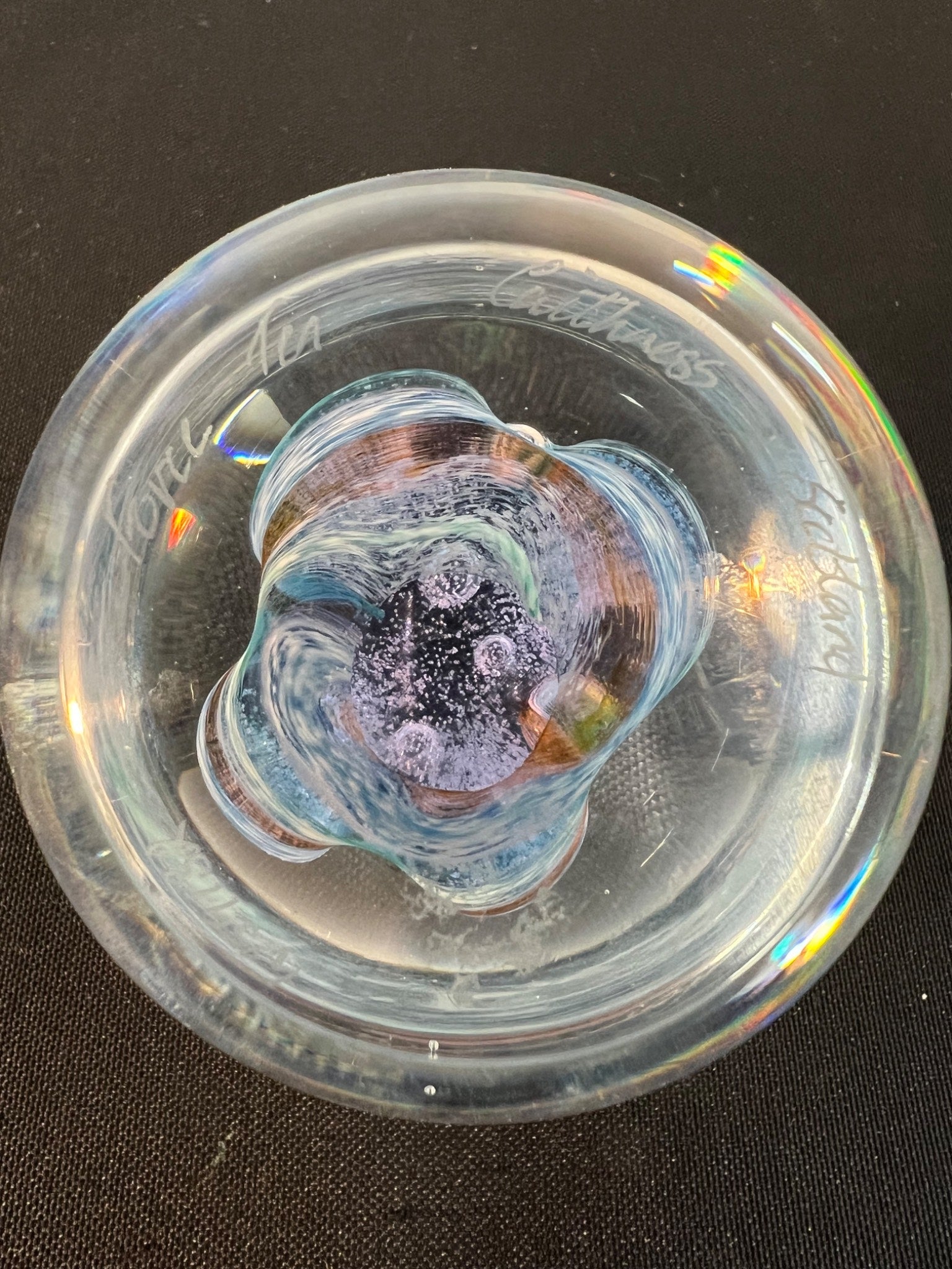 Clear glass pipe with swirling design on a black background