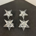 Four clear star-shaped objects on a black surface
