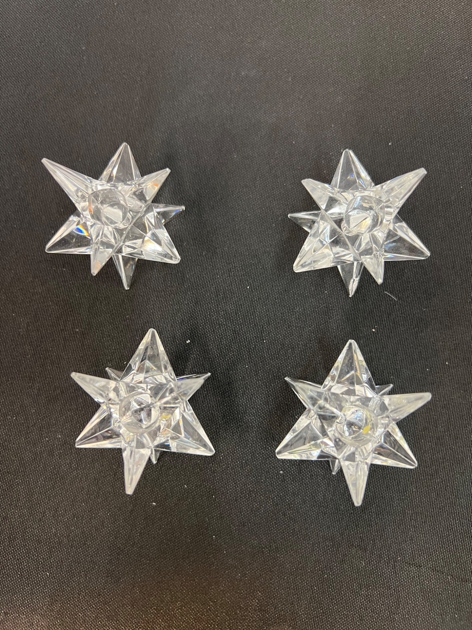 Four clear star-shaped objects on a black background