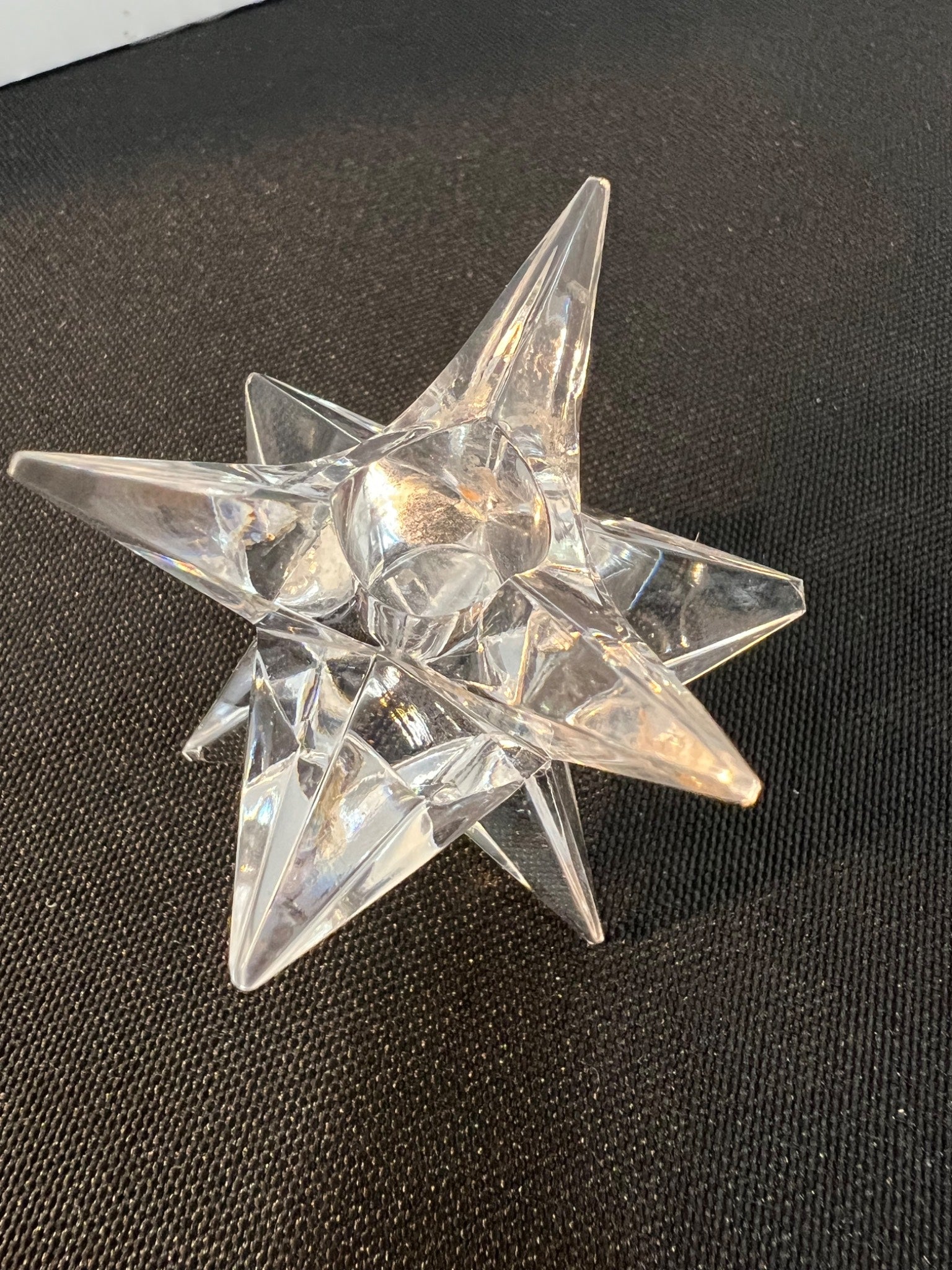 Clear geometric star-shaped object on a black background