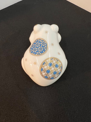 Decorative ceramic bear figurine with blue and gold patterns on a black background