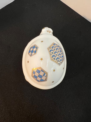 Decorative shell with blue and gold patterns on a black surface