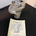 Glass bear figurine with a certificate on a dark surface