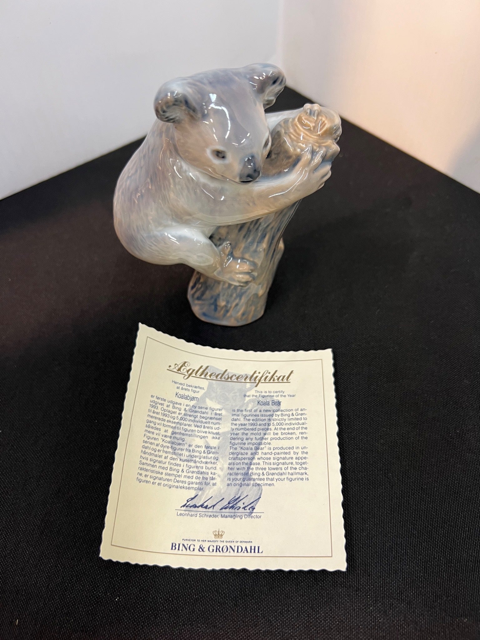Glass bear figurine with a certificate on a dark surface