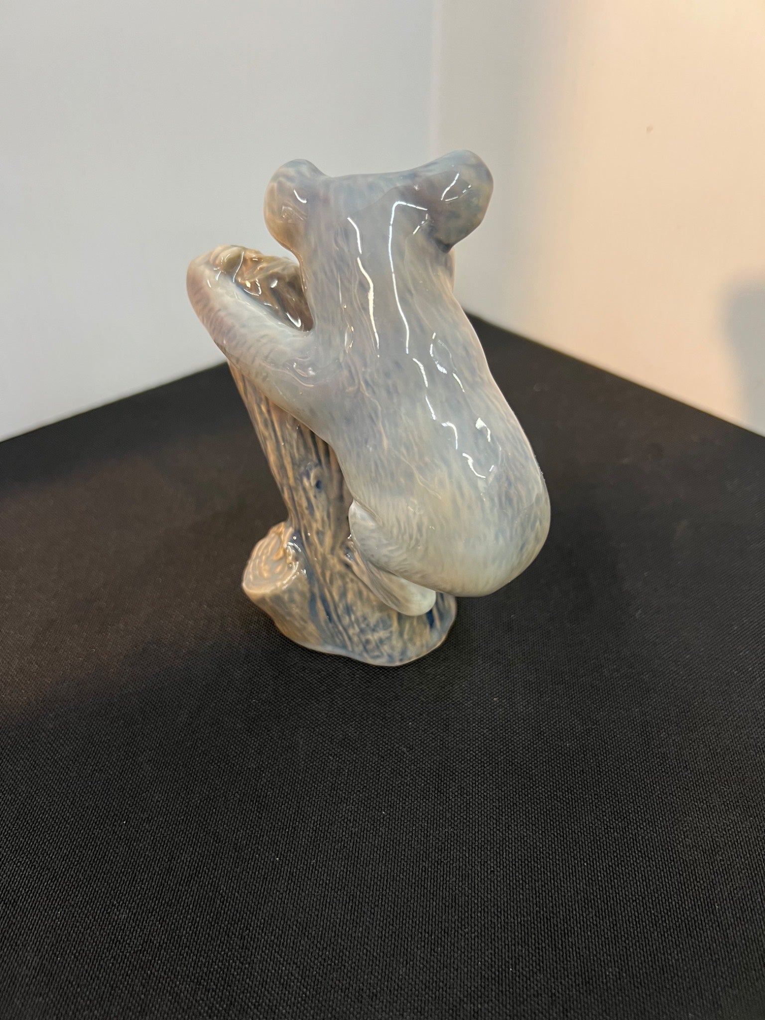 Ceramic bear figurine on a black surface with a neutral background