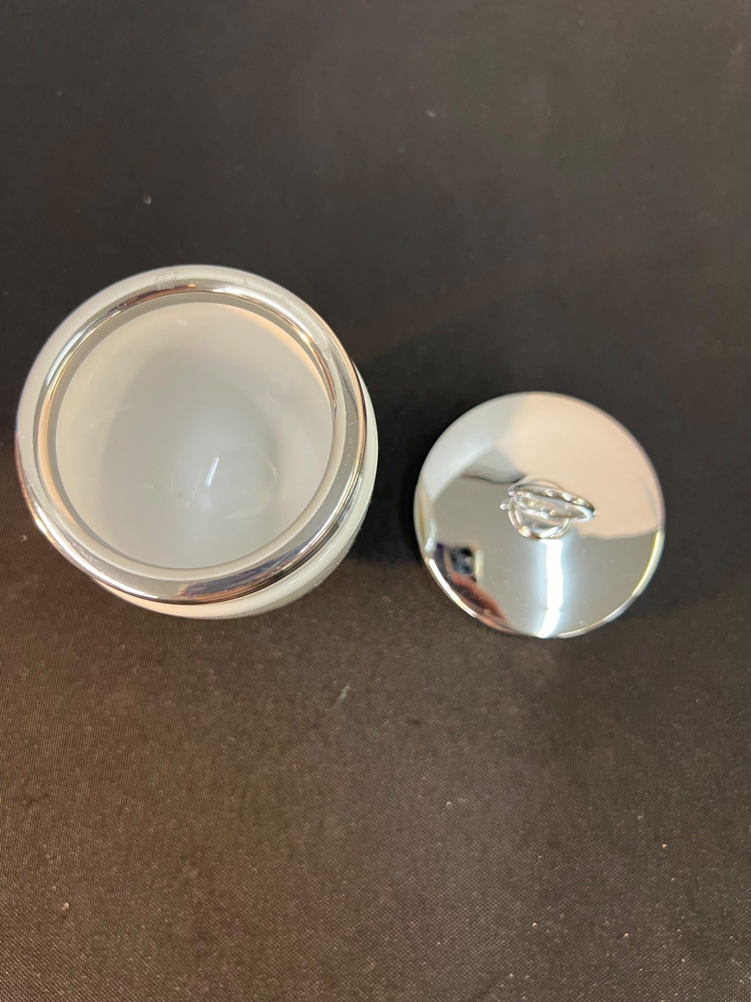 Silver container with a lid on a dark surface