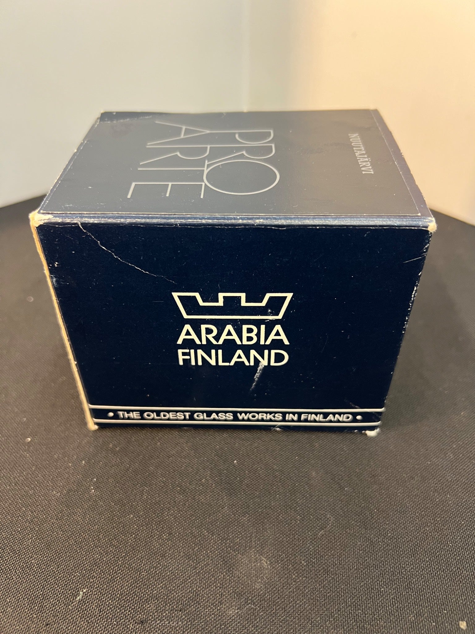 Box with 'Arabia Finland' branding on a dark surface