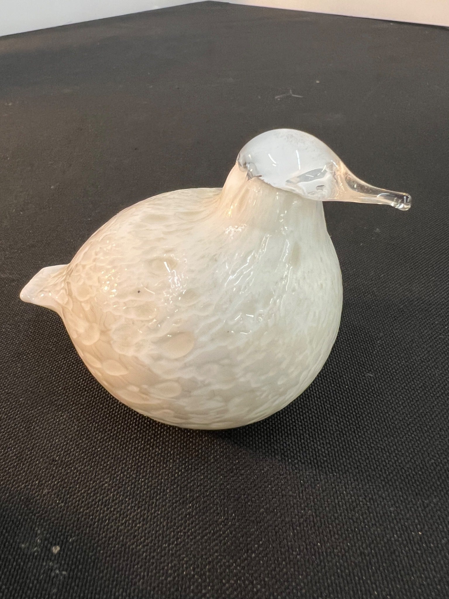 Glass duck ornament on a black surface