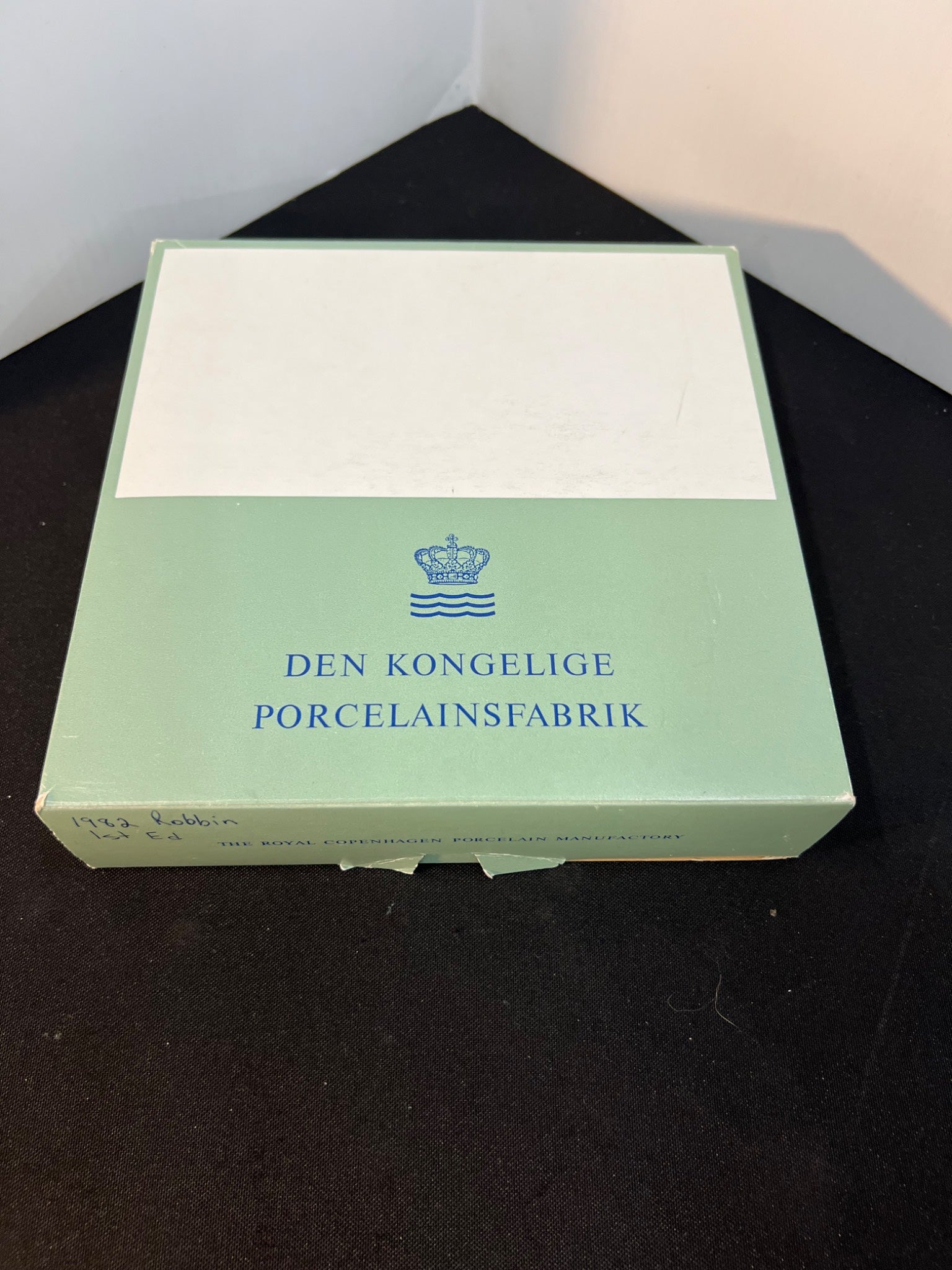 Green box with 'Den Kongelige Porcelainsfabrik' branding on a black surface.