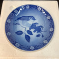 Blue ceramic plate with bird design on a white background