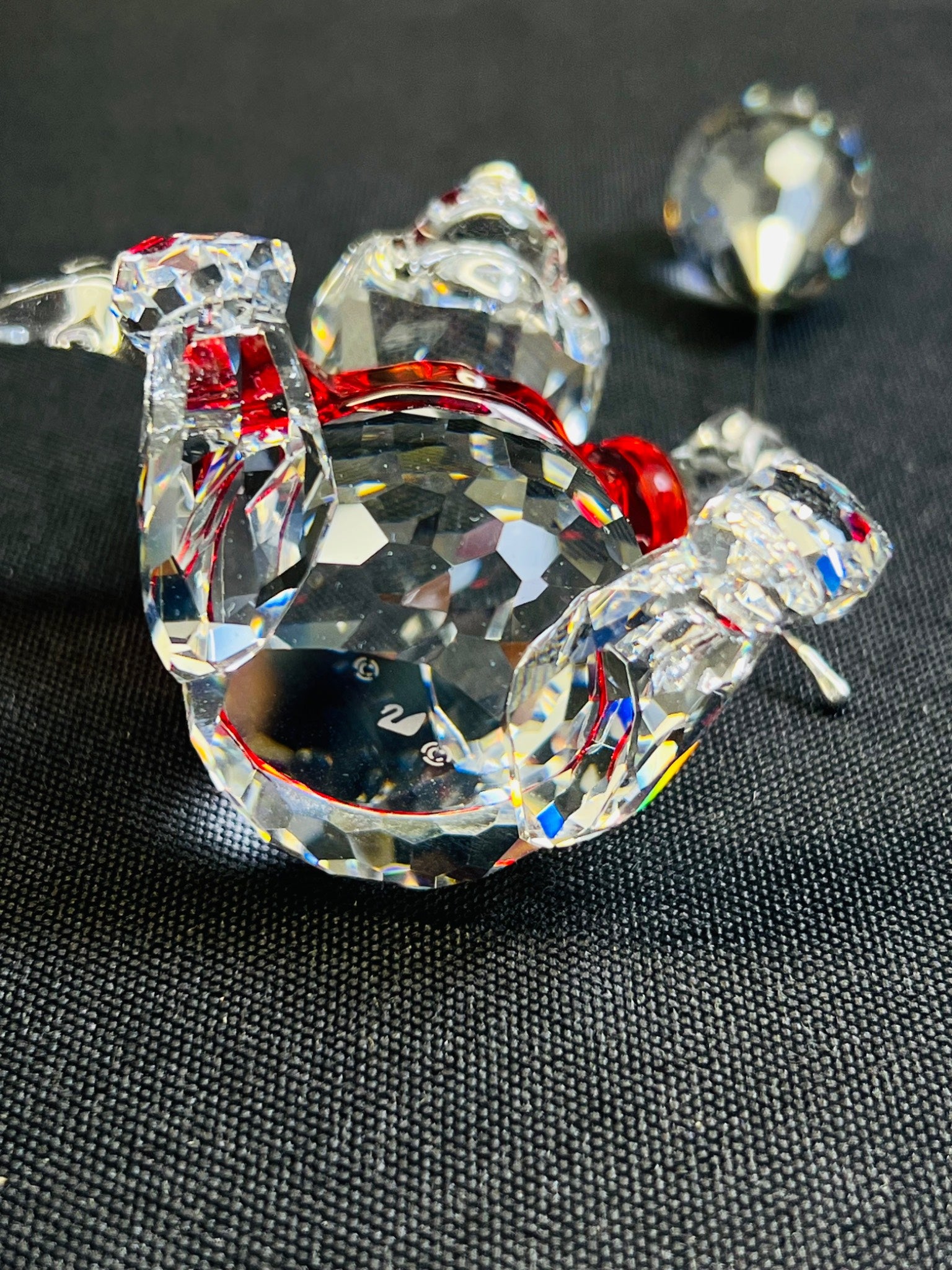 Crystal candy sculpture with red center on a dark textured surface