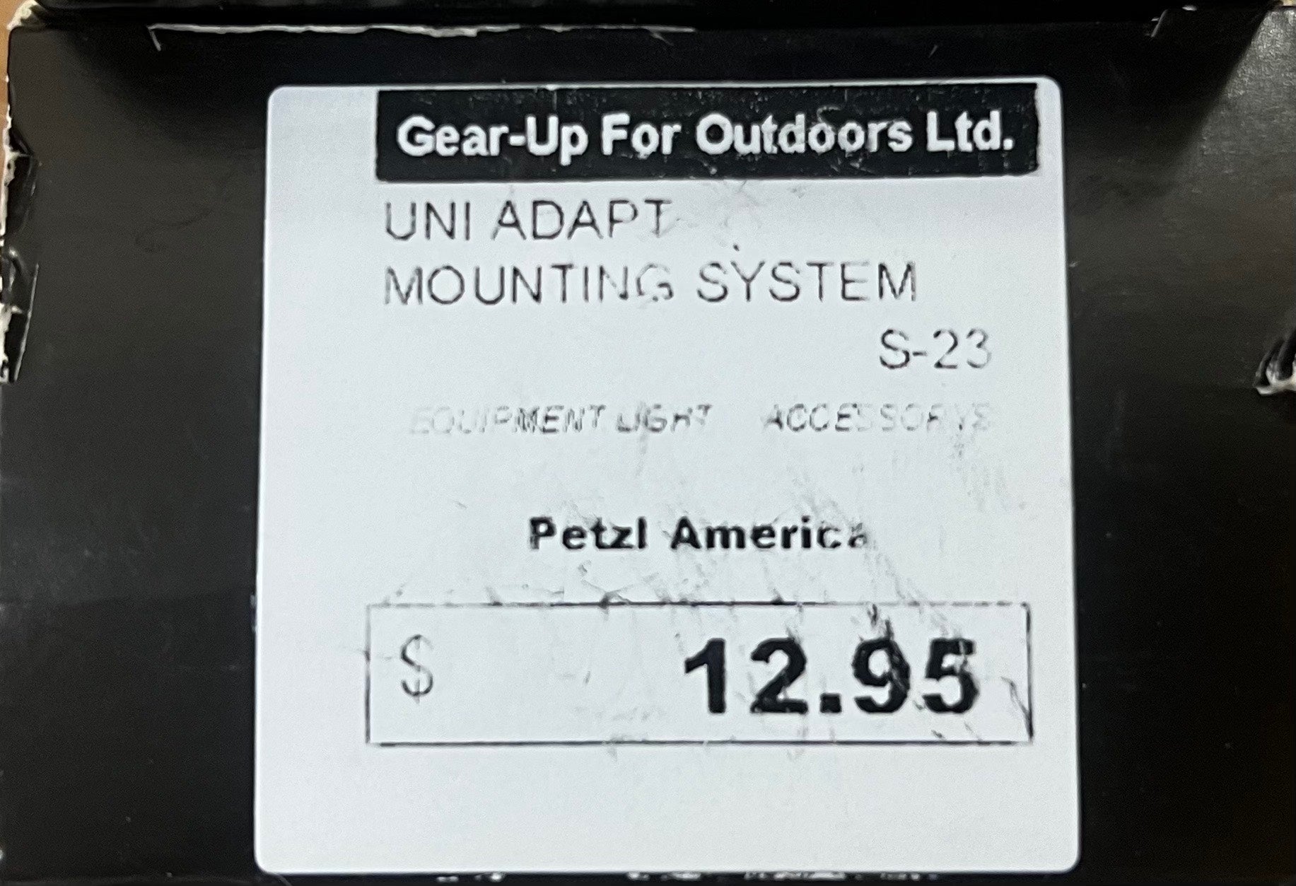 Label for Petzl America UNI ADAPT MOUNTING SYSTEM with price tag on a black background