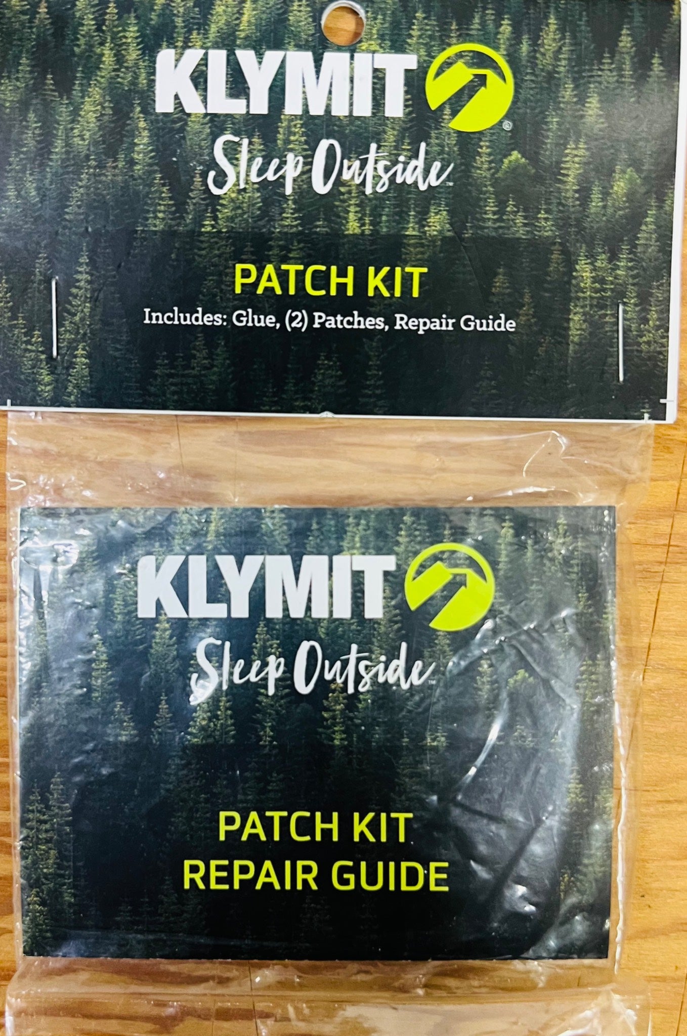 Klymit patch kit with repair guide on a wooden surface
