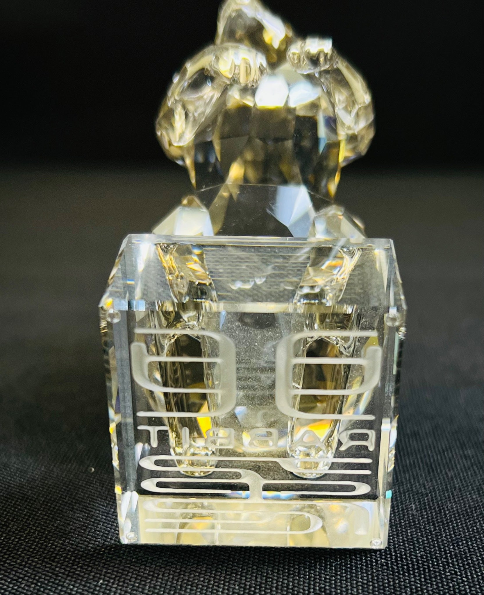 Clear crystal sculpture of a couple embracing on a black background