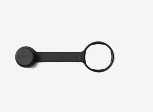 Black keychain device with a circular tag on a white background