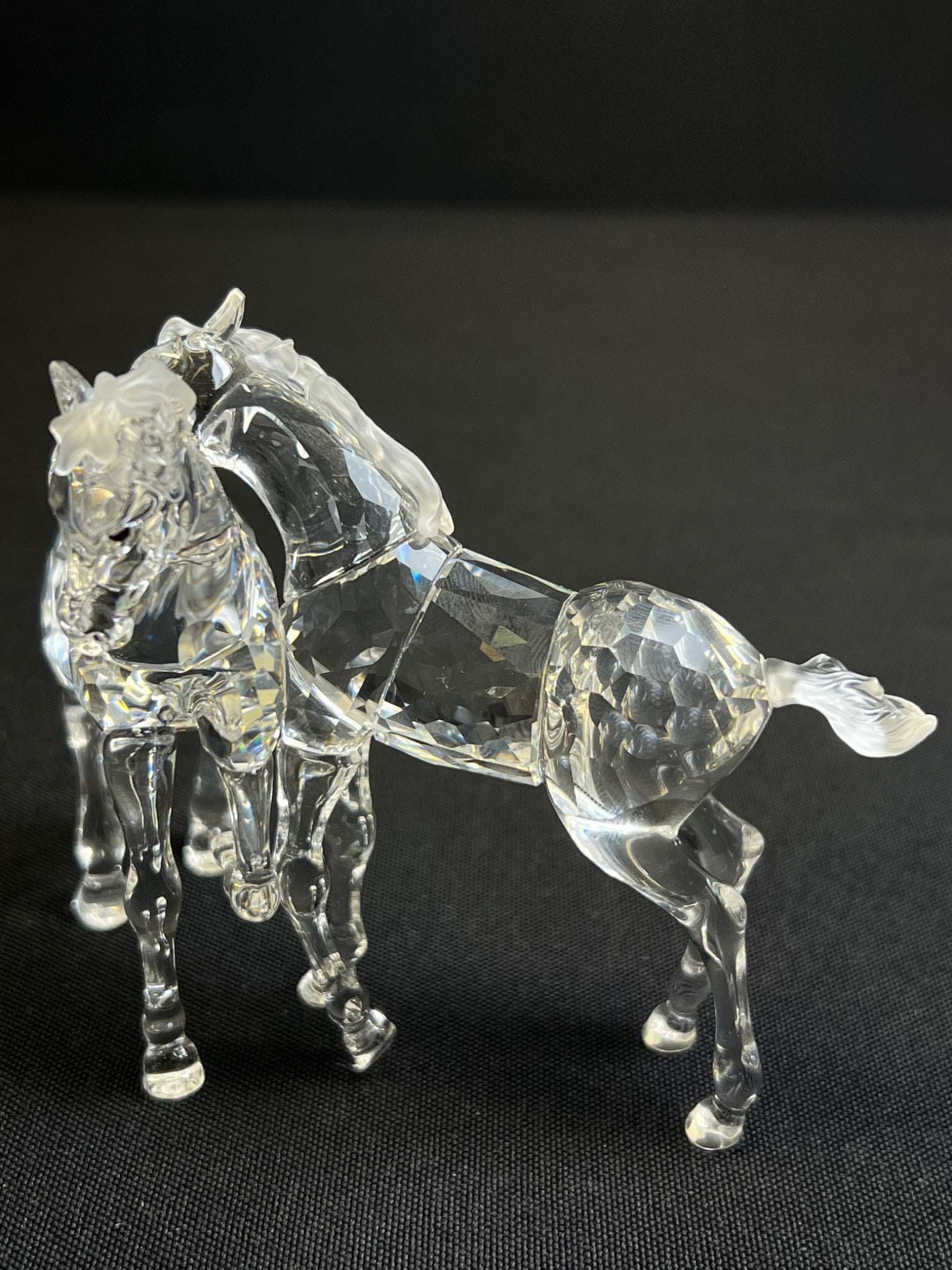 Clear glass horse figure on a black background