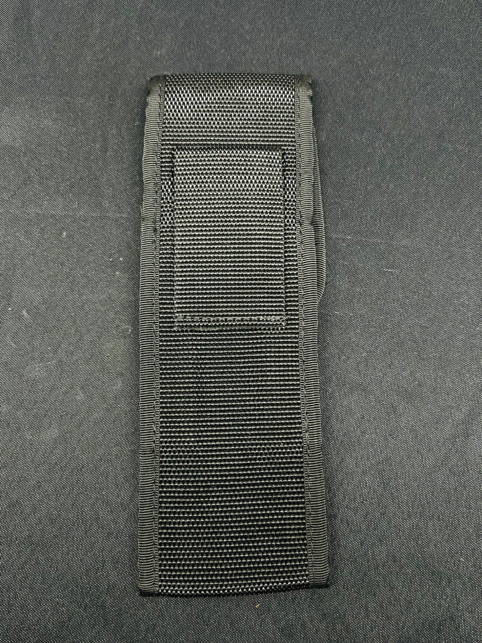 Black tactical pouch on a gray background