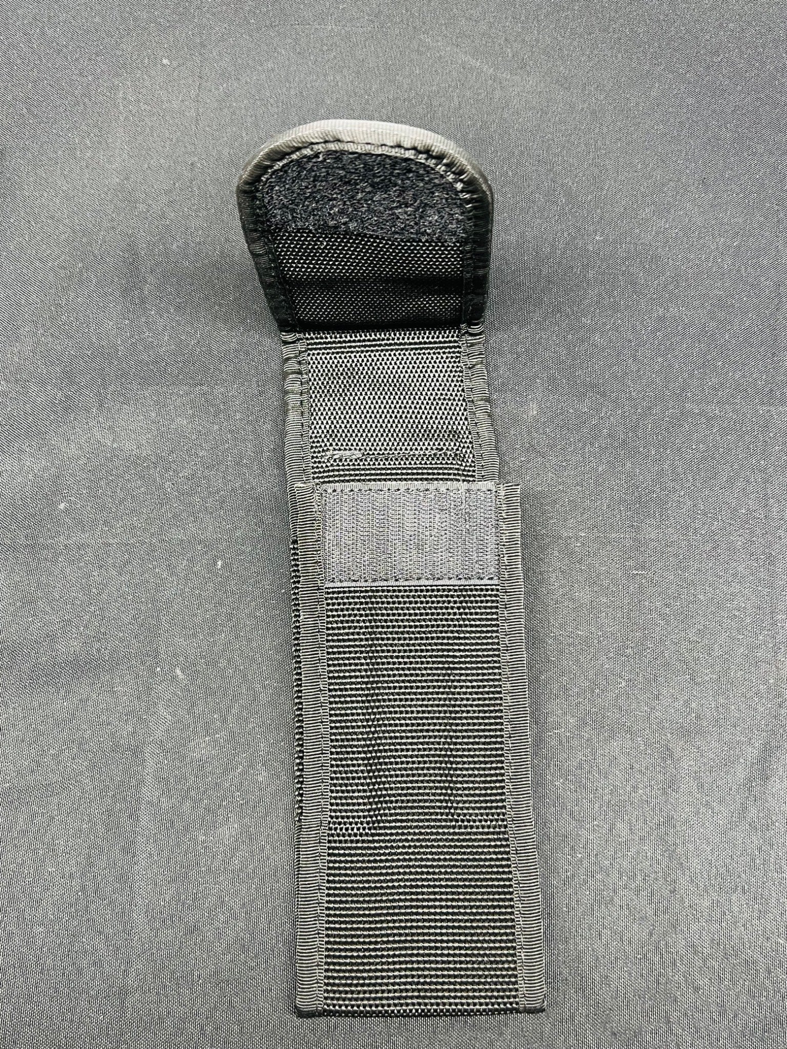 Black tactical knife sheath on a gray background