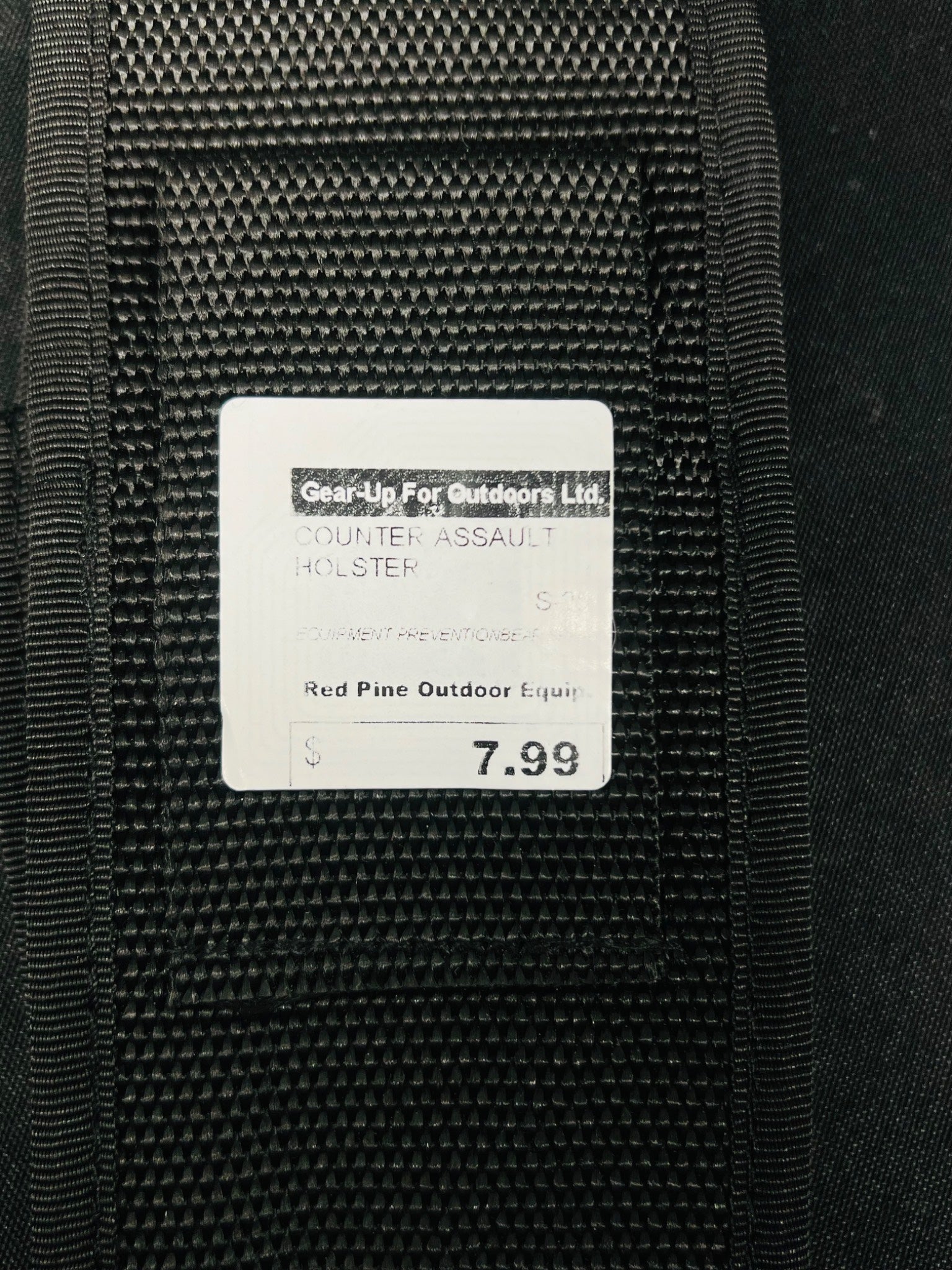 Black tactical holster with a label on a black background