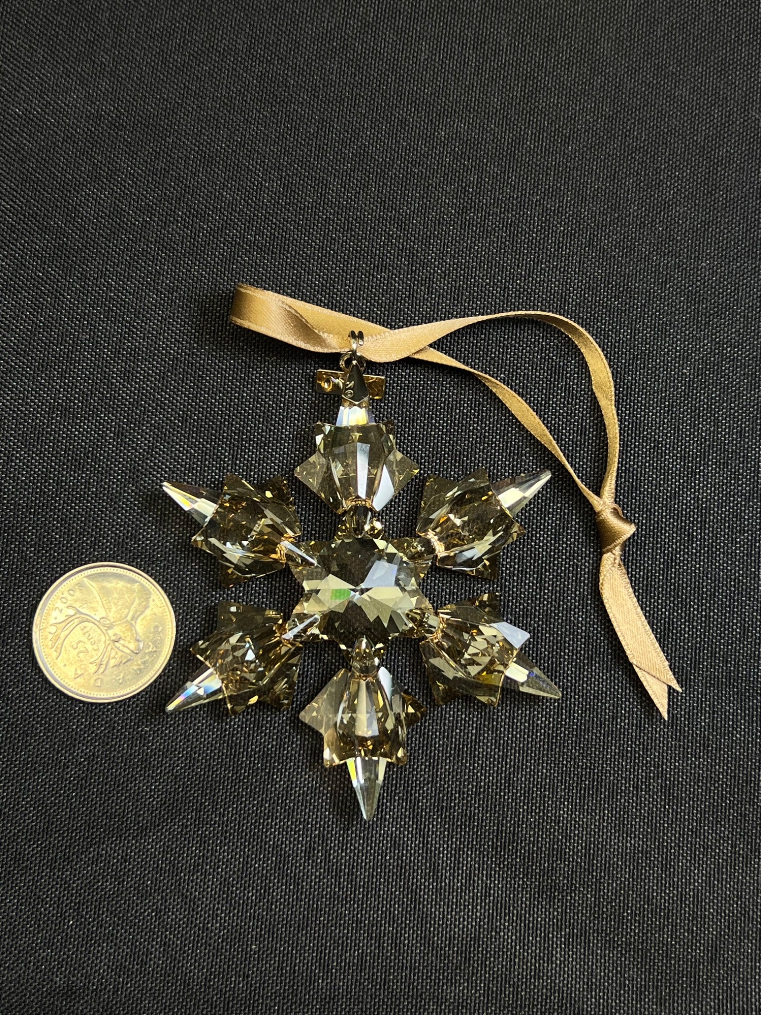Crystal snowflake ornament with a ribbon on a black background