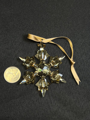 Crystal snowflake ornament with a ribbon on a black background