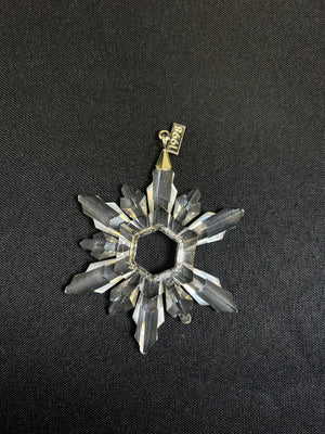 Decorative star-shaped object with a gold accent on a black background