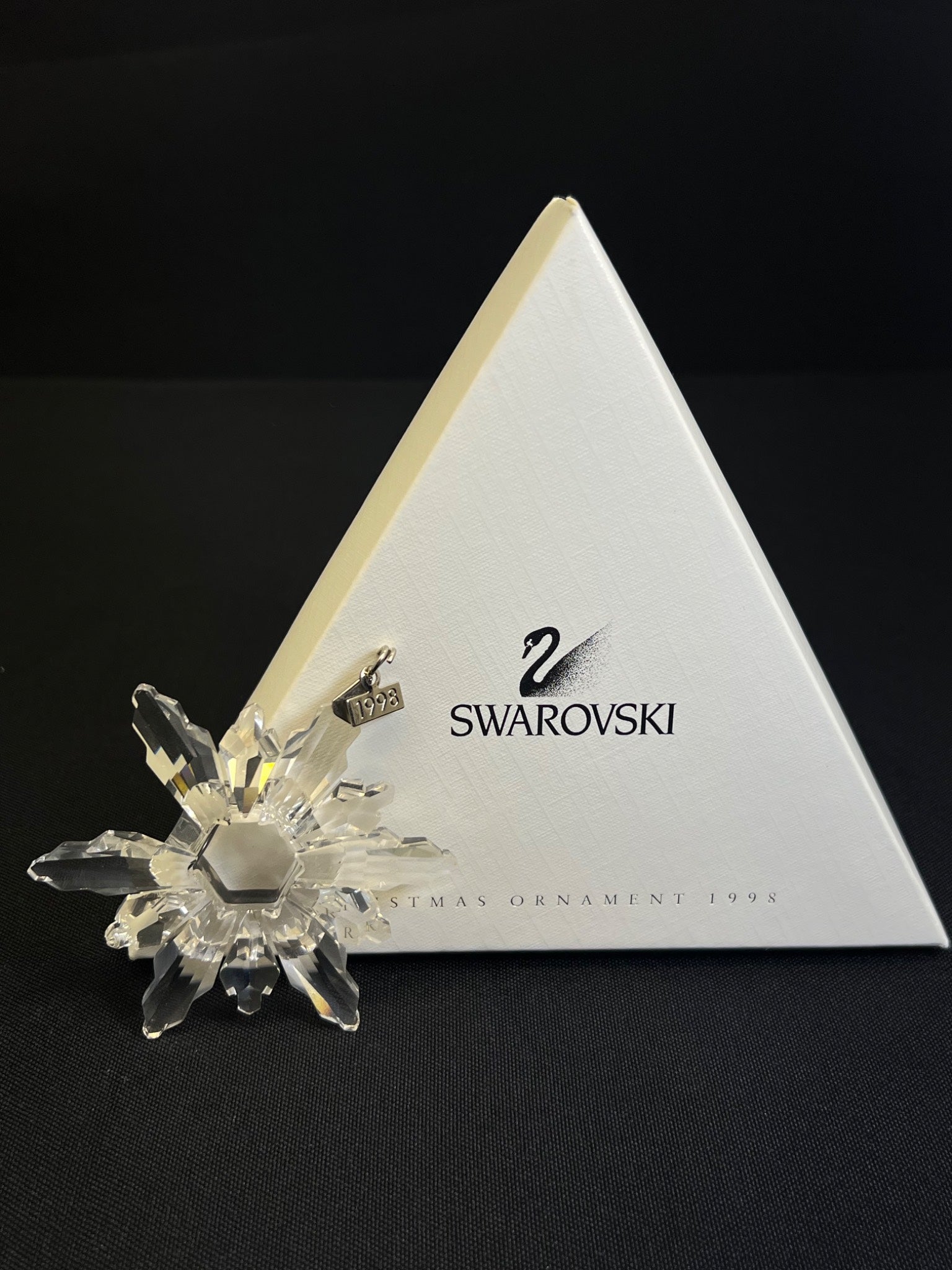 Swarovski crystal ornament on a branded Swarovski stand against a black background