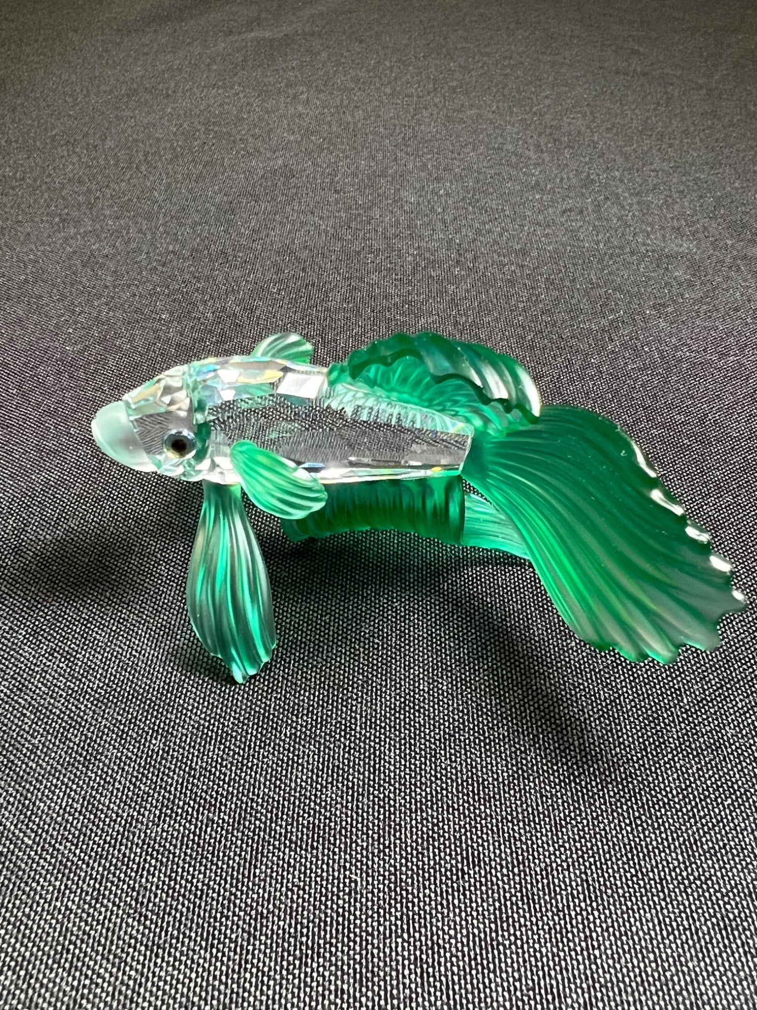 Glass fish figurine on a gray background