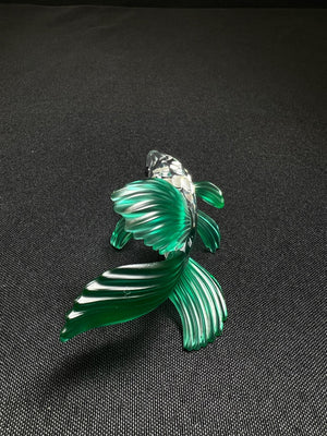 Green fish-shaped object on a black background