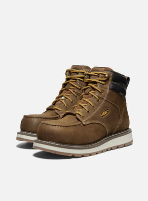 Brown leather boots with white soles on a light gray background