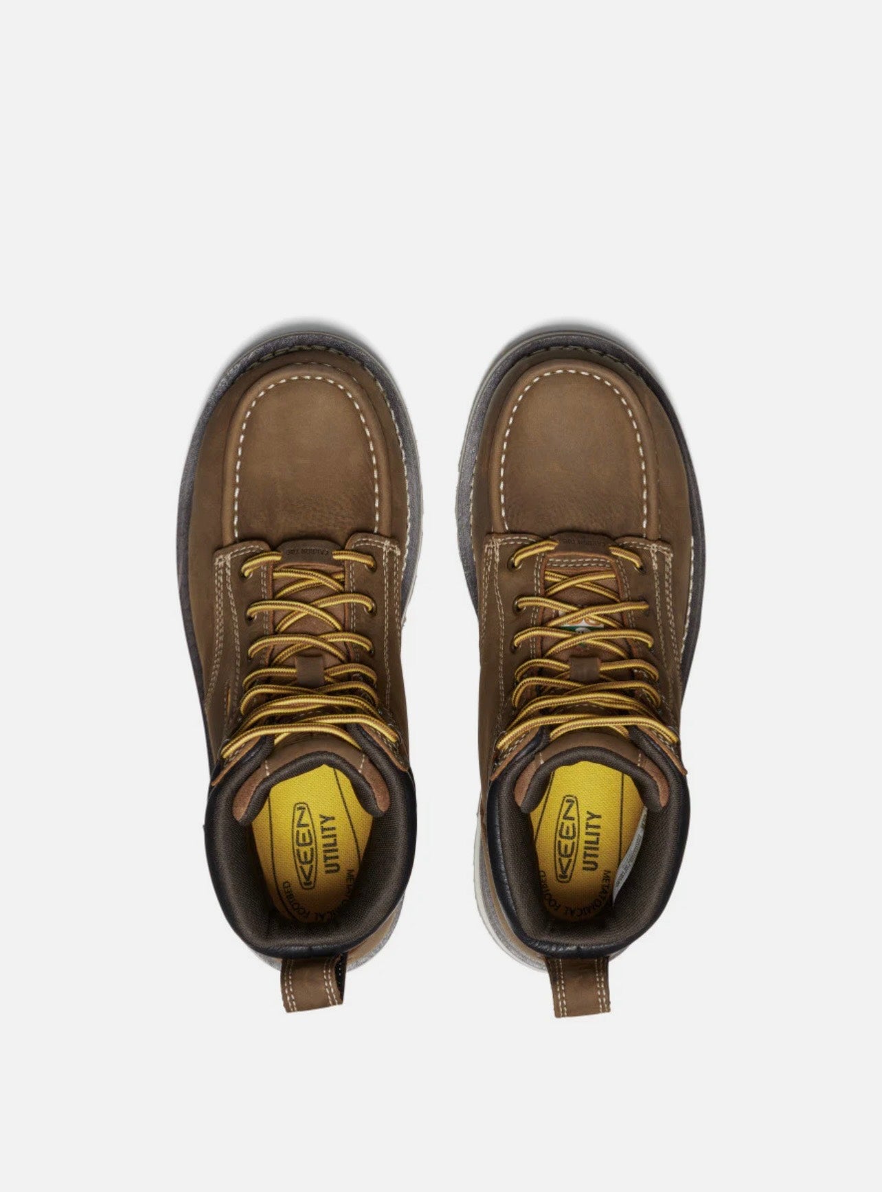 Pair of brown work boots with yellow laces on a white background