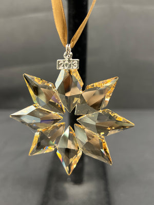 Crystal snowflake ornament with '2013' on a dark background