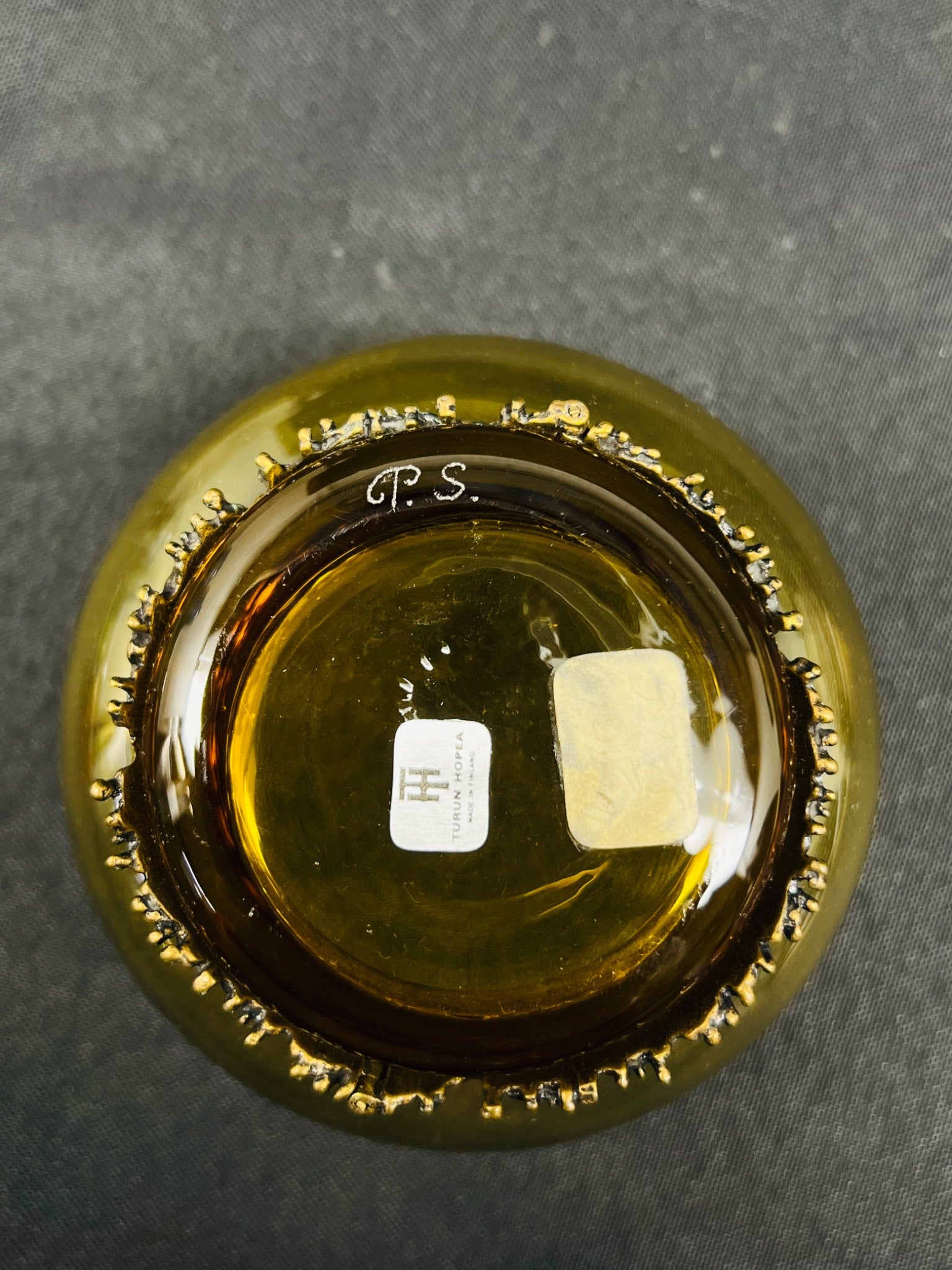 Close-up of a bottle cap with 'P.S.' branding on a dark surface