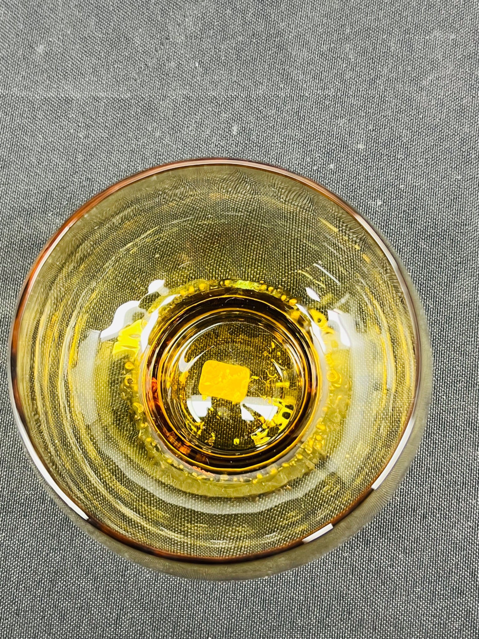 Clear glass bowl with yellowish tint on a gray background