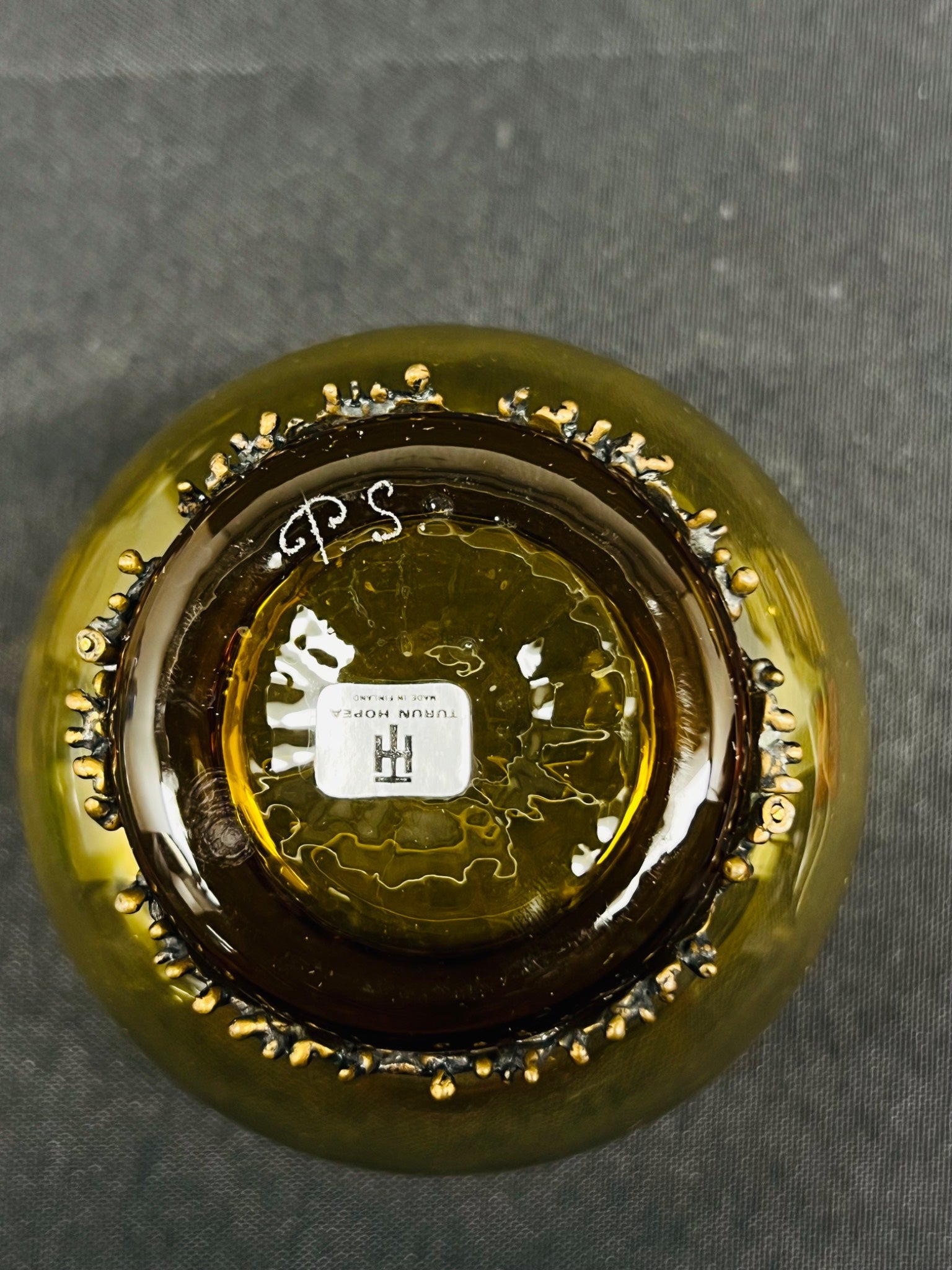 Close-up of a bottle cap with 'PS' branding on a dark background