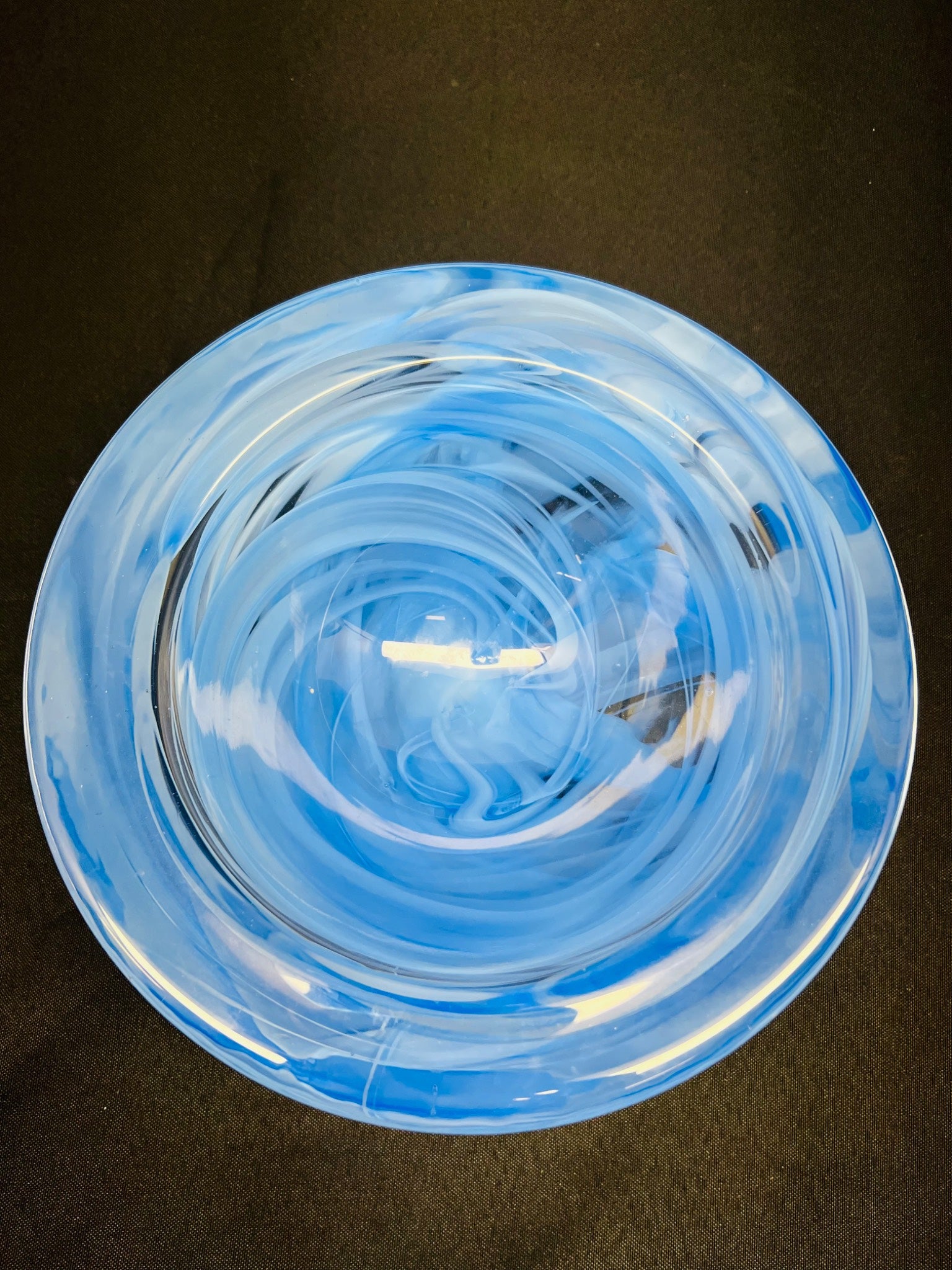 Clear blue glass bowl on a dark background